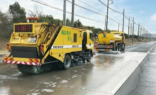 幹線道路の散水車（前）とスイーパー車（後）による清掃作業